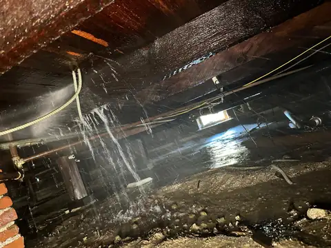 Burst water pipe spraying under a Los Angeles home before emergency repair